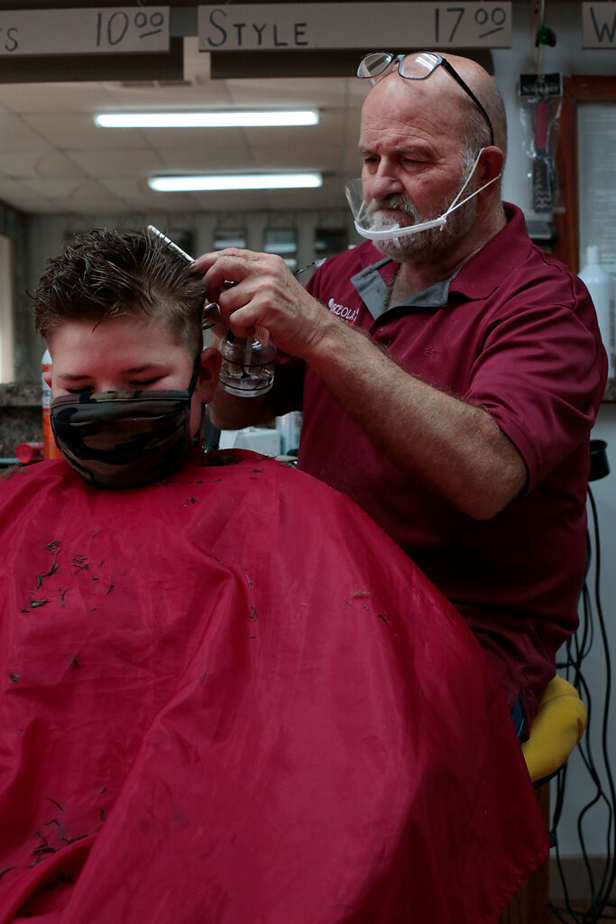 Billy Quessenberry cuts Logan Peery’s, 10, hair on Friday, Oct. 2, in the Osceola Barber and Style Shop.